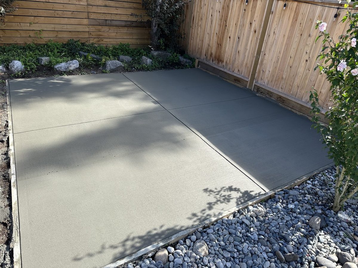 Finished broom-finish concrete pad in a backyard