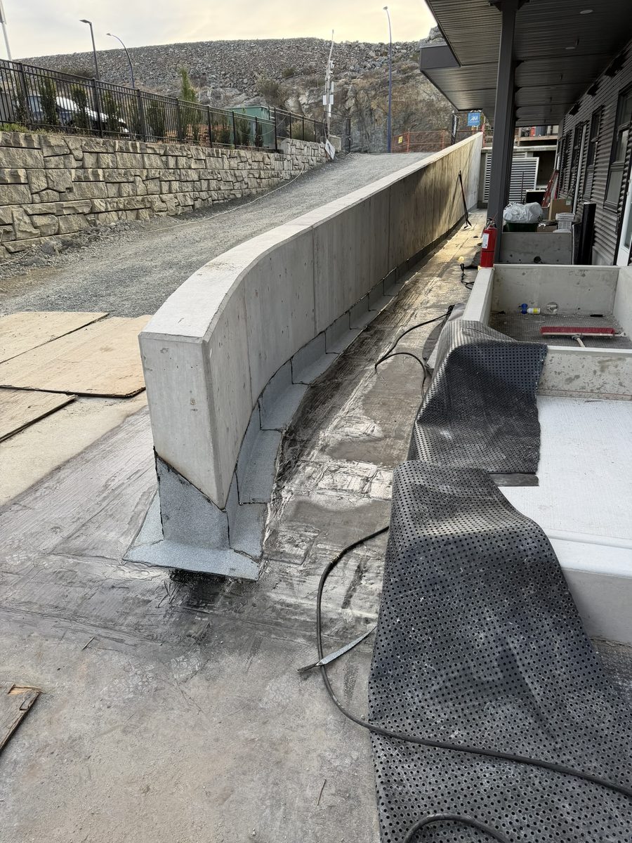 Torch-on membrane flashing running along a curved concrete wall