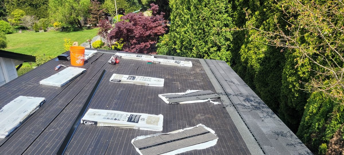 Other side of the roof with underlayment down & shingle bundles staged