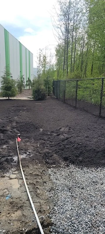 Early-stage grading and drainage preparation beside a fence line